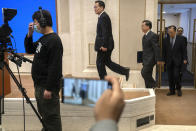 Officials arrive for a press conference at the State Council Information Office in Beijing, Saturday, Dec. 4, 2021. China's Communist Party took American democracy to task on Saturday, sharply criticizing a global democracy summit being hosted by President Joe Biden next week and extolling the virtues of its governing system. (AP Photo/Mark Schiefelbein)