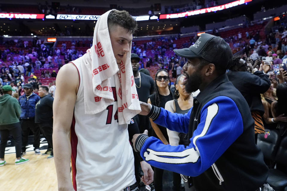 Miami Heat guard Tyler Herro, left, talks with former boxer Floyd Mayweather Jr. after an NBA basketball game between the Heat and Charlotte Hornets, Tuesday, April 5, 2022, in Miami. The Heat won 144-115. (AP Photo/Lynne Sladky)