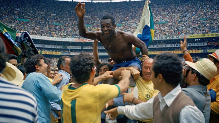 Teammates and fans lift soccer great Pele onto their shoulders after Brazil's win over Italy in the 1970 World Cup final.