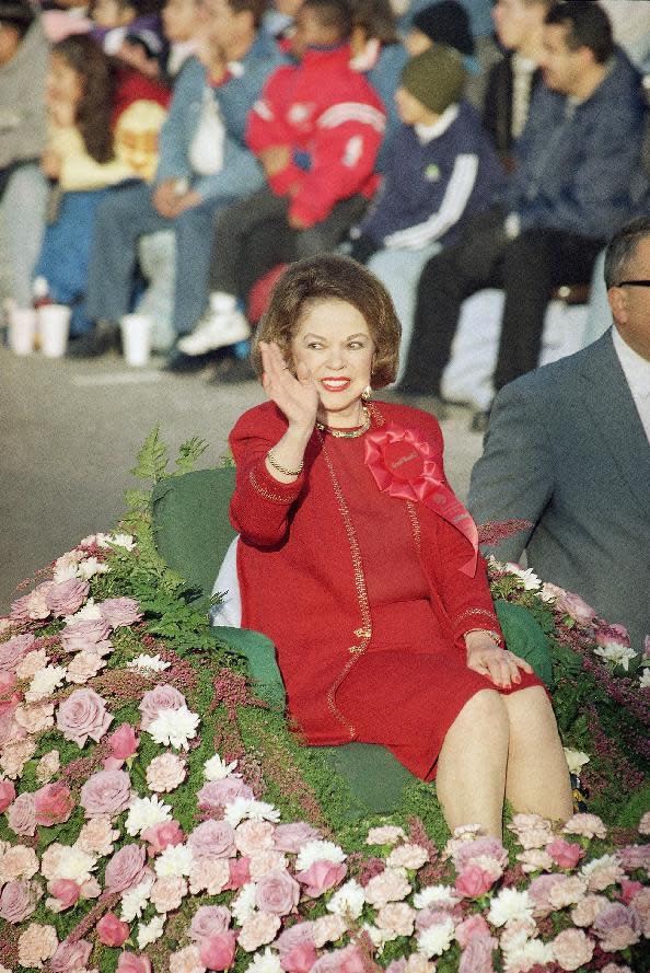 FILE - In this Jan. 1, 1999 file photo, Grand Marshall Shirley Temple Black waves to the crowd as she rides along the 110th Tournament of Roses Parade route in Pasadena, California. Shirley Temple, the curly-haired child star who put smiles on the faces of Depression-era moviegoers, has died. She was 85. Publicist Cheryl Kagan says Temple, known in private life as Shirley Temple Black, died surrounded by family at her home near San Francisco. (AP Photo/Damian Dovarganes, File)