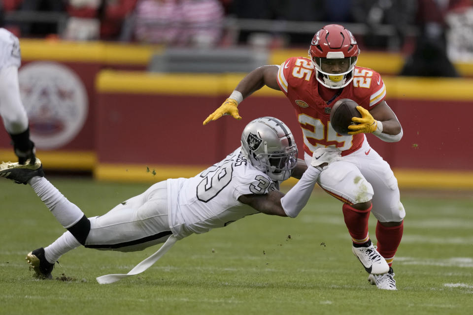 Kansas City Chiefs running back Clyde Edwards-Helaire (25) runs with the ball as Las Vegas Raiders cornerback Nate Hobbs (39) defends during the second half of an NFL football game Monday, Dec. 25, 2023, in Kansas City, Mo. (AP Photo/Charlie Riedel)