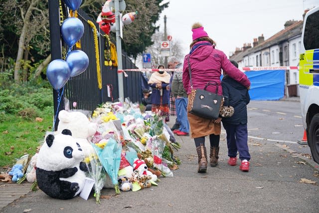 Flowers and toys left near the scene of a fire