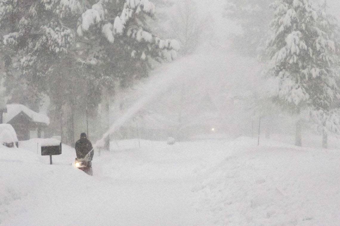 A person uses a snow blower to clear snow from a driveway during a storm, Saturday, March 2, 2024, in Truckee, Calif. A powerful blizzard howled Saturday in the Sierra Nevada as the biggest storm of the season shut down a long stretch of Interstate 80 in California and gusty winds and heavy rain hit lower elevations, leaving tens of thousands of homes without power. Brooke Hess-Homeier/AP