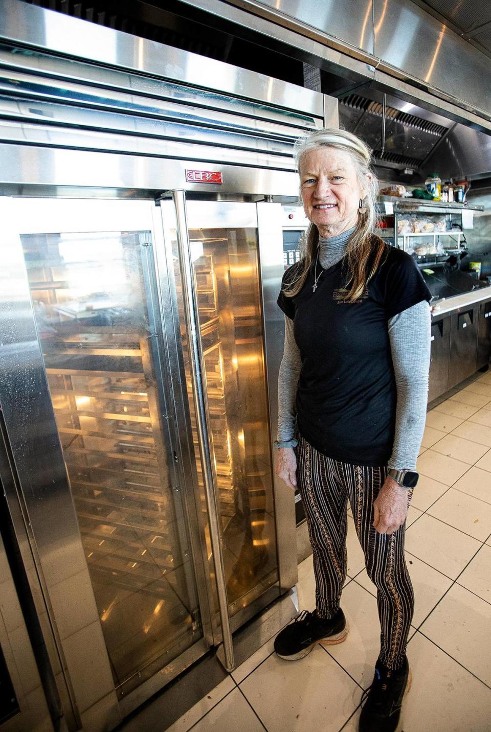 Sheila McCann poses for a picture at Farmhouse House of Bread, which opened at 1025 Farmhouse Lane near the San Luis Obispo County Regional Airport in May 30, 2023. She stands by one of the two commercial bakery ovens.