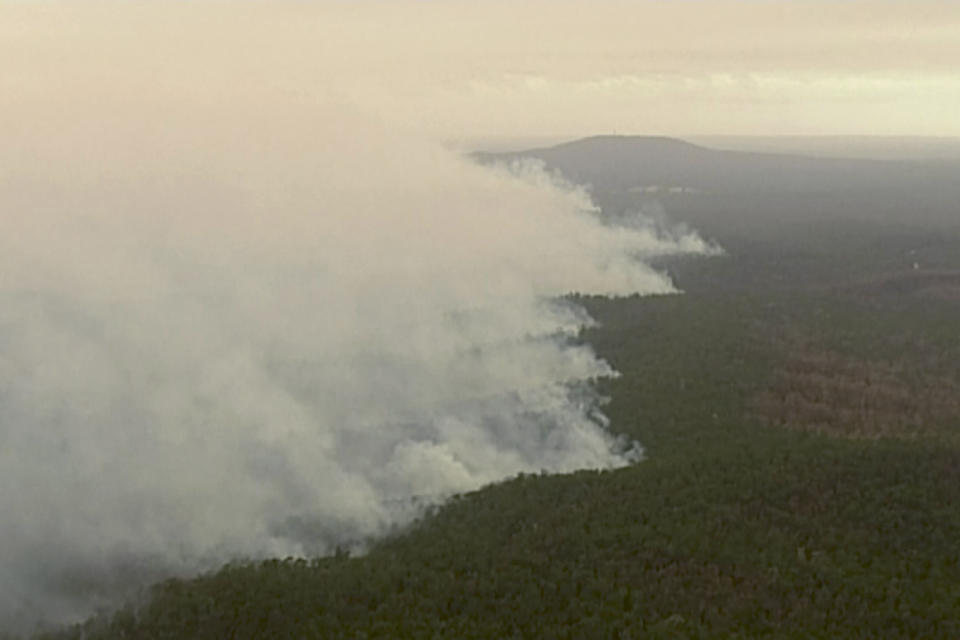 In this image made from video, an aerial view shows wildfires in the forests of Gippsland, Victoria, Australia, Dec. 31, 2019. Wildfires burning across Australia's two most-populous states have trapped residents of a seaside town in apocalyptic conditions, destroyed many properties and caused at least two fatalities. (Australian Broadcasting Corporation, Channel 7, Channel 9 via AP)