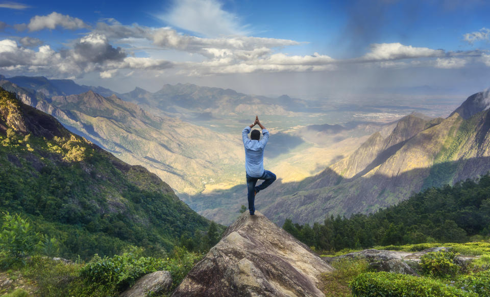 Man doing yoga on the peak of&nbsp;a mountain in Tamilnadu, India. (Photo: © Naufal MQ via Getty Images)