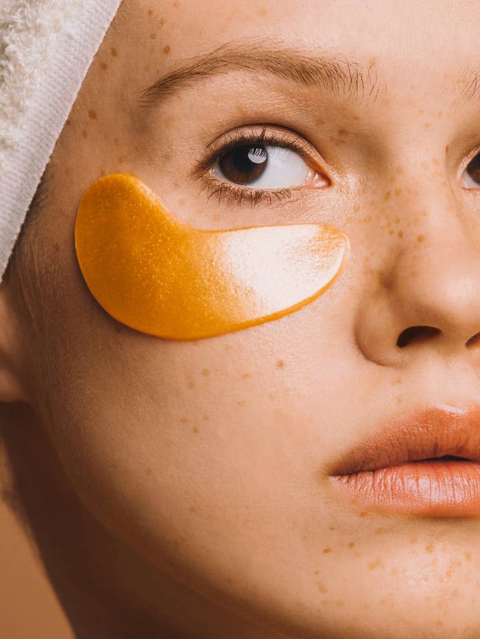 An up-close image of a girl with gold-colored eye patches on her face