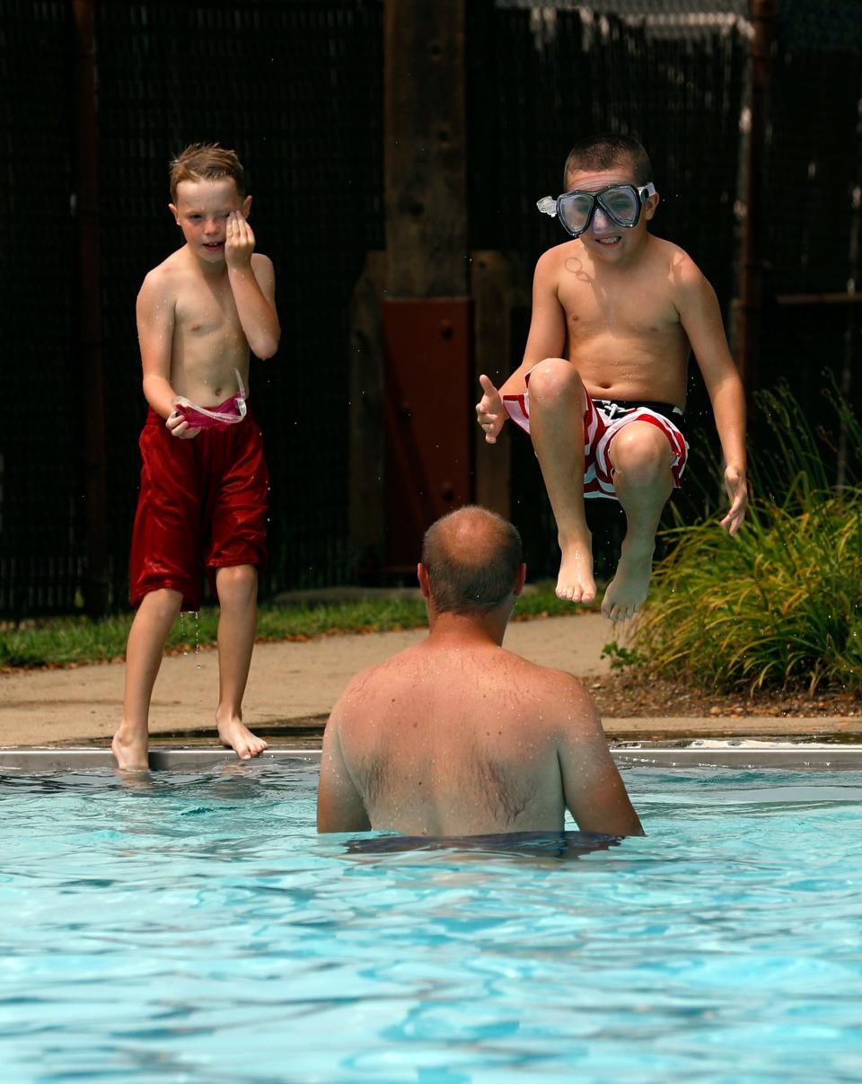 Reilly Brant, 9, dives into Tiki Pool toward his neighbor Travis Keirns while Evan Keirns, 7, wipes water from his eye in this file photo from Wednesday, Aug. 15, 2018, in Lancaster. The area pools are a popular escape from the summer heat.