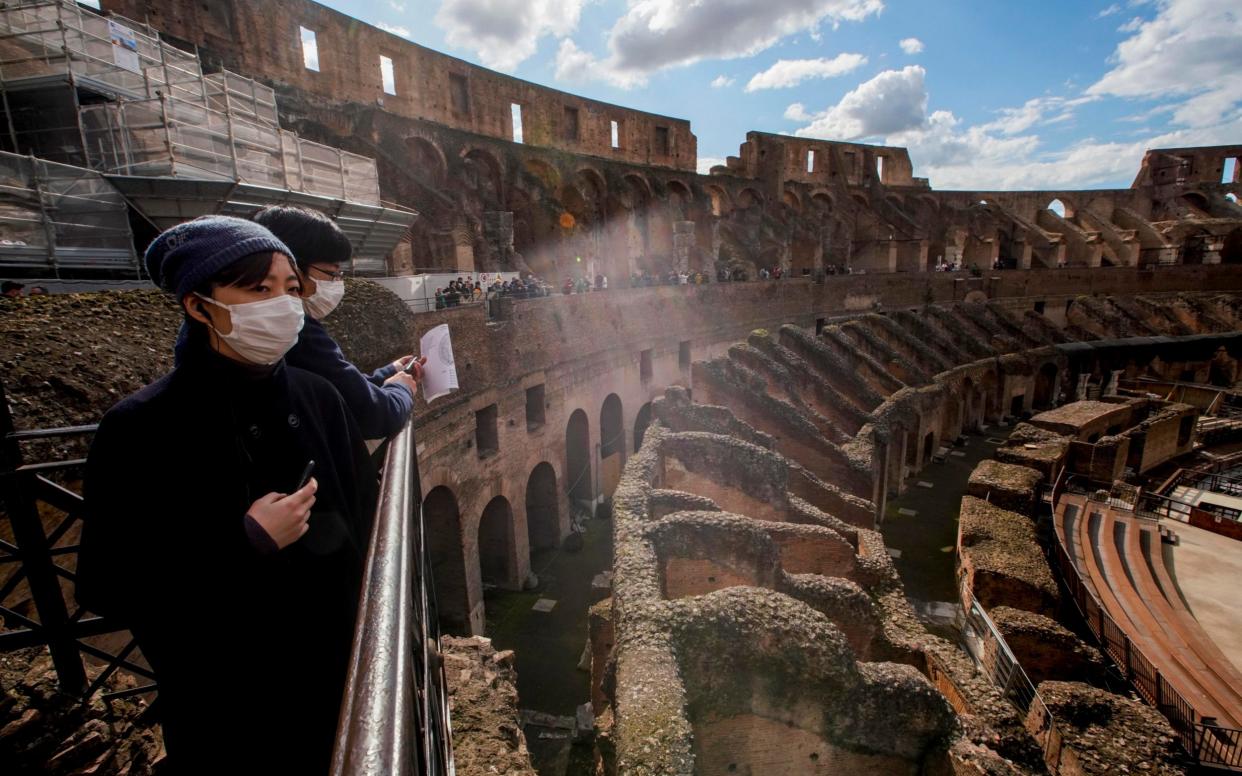 Tourists visit the Colosseum, in Rome - AP