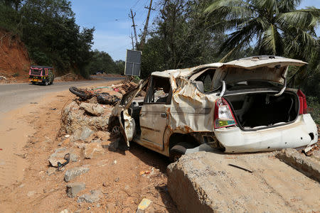 An auto-rickshaw drives past a damaged car from a landslide in Idukki, Kerala, India, September 6, 2018. REUTERS/Sivaram V