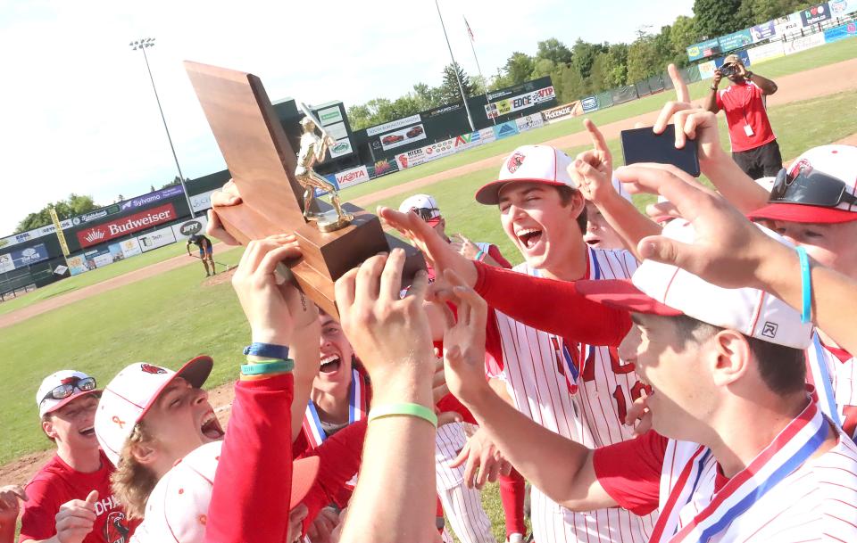 The CVU Redhawks get their hands on the trophy after their 6-0 win over Mount Anthony in the D1 State Championship game on Saturday afternoon at Centennial Field.