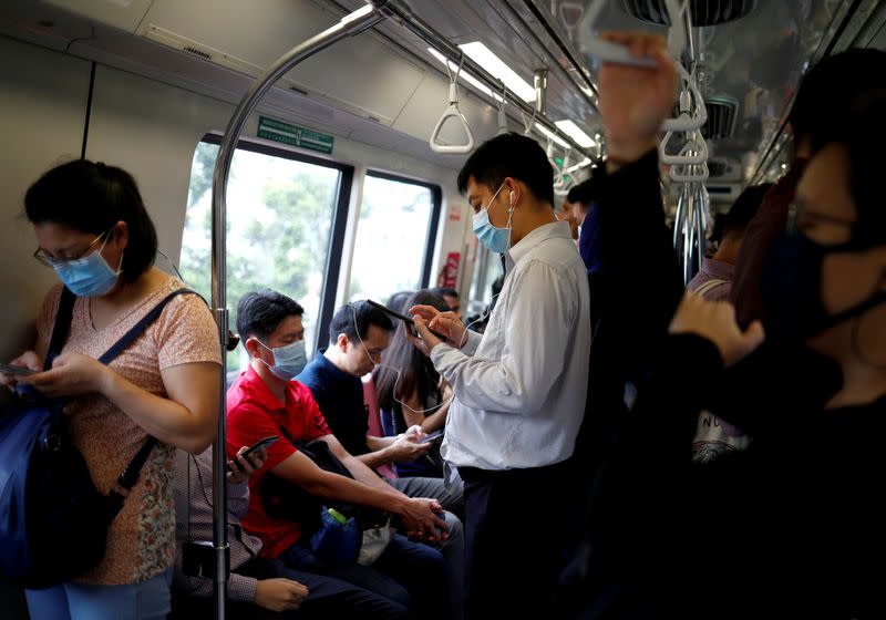 Commuters wearing masks in precaution of the coronavirus outbreak are pictured in a train during their morning commute in Singapore