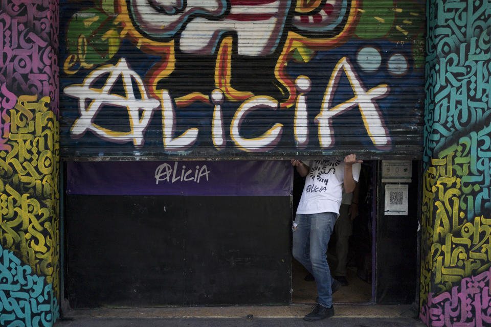 A worker at the iconic counterculture venue Multiforo Alicia opens the steel curtain to let people in during the sale of posters and records of the groups that have performed at the site in Mexico City, Saturday, March 11, 2023. The name of the venue comes from an Italian counterculture radio station from the 1970s, Radio Alice, and Lewis Carrol’s Alice in Wonderland. (AP Photo/Eduardo Verdugo)