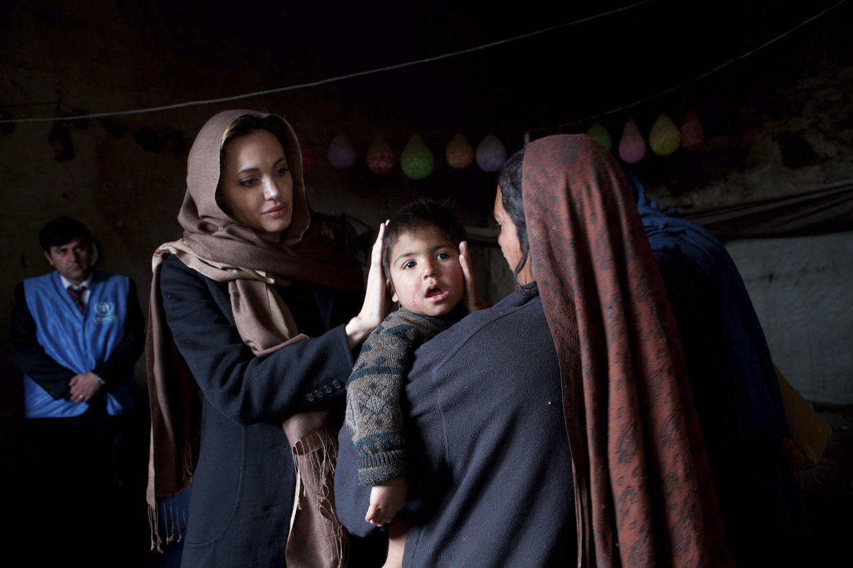 UNHCR Goodwill Ambassador Angelina Jolie (L) meets with  35-year-old Khanum Gul, a mother of eight and her youngest son, Samir at their makeshift home at Tamil Mill Bus site in Kabul in this March 2, 2011 handout photo.

 REUTERS/UNHCR/Jason Tanner/Handout (AFGHANISTAN - Tags: POLITICS ENTERTAINMENT) NO COMMERCIAL OR BOOK SALES. FOR EDITORIAL USE ONLY. NOT FOR SALE FOR MARKETING OR ADVERTISING CAMPAIGNS. THIS IMAGE HAS BEEN SUPPLIED BY A THIRD PARTY. IT IS DISTRIBUTED, EXACTLY AS RECEIVED BY REUTERS, AS A SERVICE TO CLIENTS. MANDATORY CREDIT
