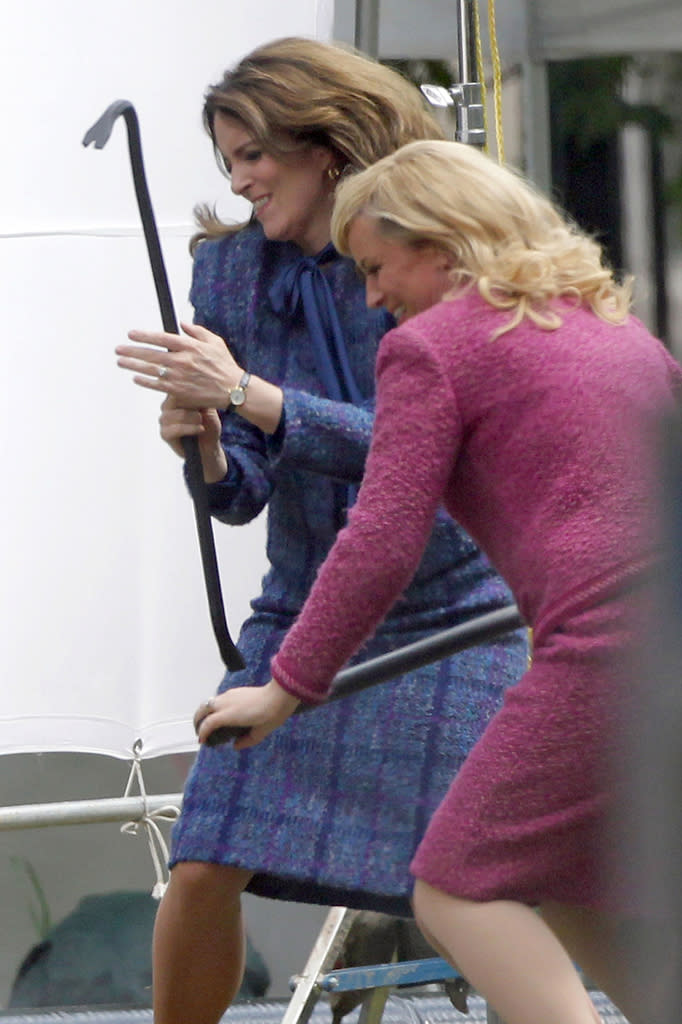 **EXCLUSIVE** FIGHT! FIGHT! Tina Fey and Amy Poehler, dressed in their news anchor attire, gang up on Sacha Baron Cohen with a crowbar on the set of 'Anchorman 2' in Atlanta