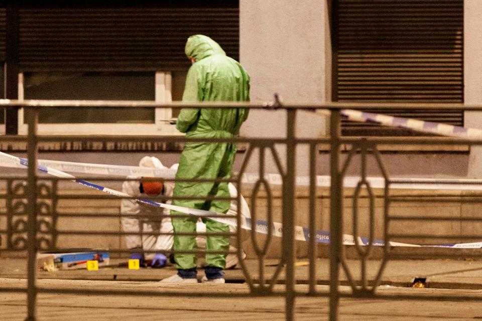 Police and inspectors work in an area where the shooting took place in the center of Brussels. (AP)