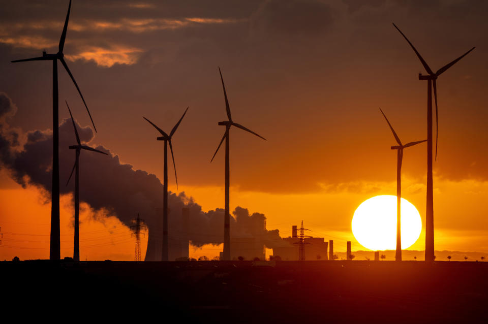 Archivo - Sale vapor de una planta eléctrica a carbón cerca de unas turbinas eólicas en Niederaussem, Alemania, mientras sale el sol el 2 de noviembre de 2022. Alemania, un firme defensor de la energía limpia, recurrió al carbón y al petróleo para resolver sus necesidades de energía a corto plazo. (AP Foto/Michael Probst, Archivo)