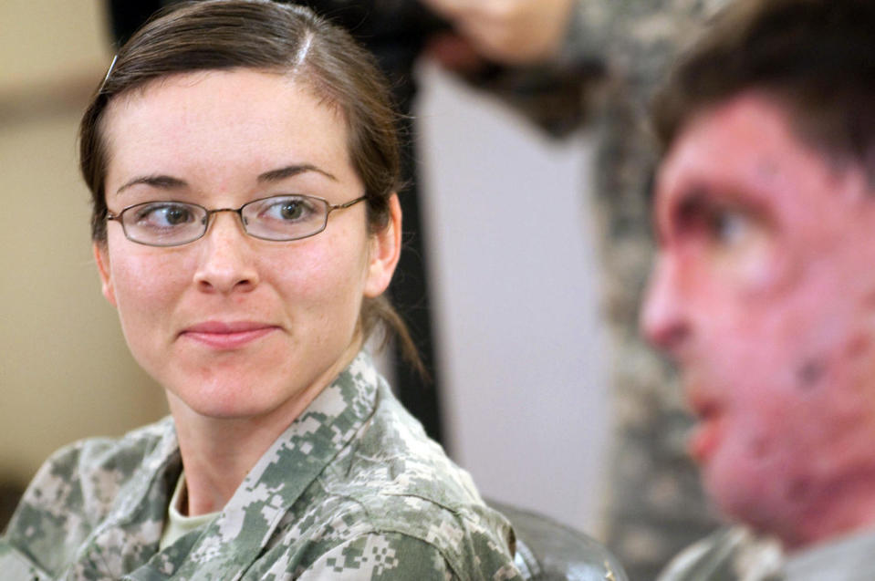 Capt. Amy Brown, a dietitian, listens as her husband, Capt. Sam Brown, tells the story of his injury while visiting Camp Ramadi, Iraq, in 2009. (Spc. Michael J MacLeod / U.S. Army)