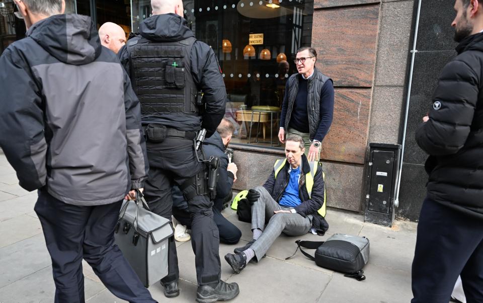 An injured man sits on the pavement after horses ran in an eastward direction along Aldwych