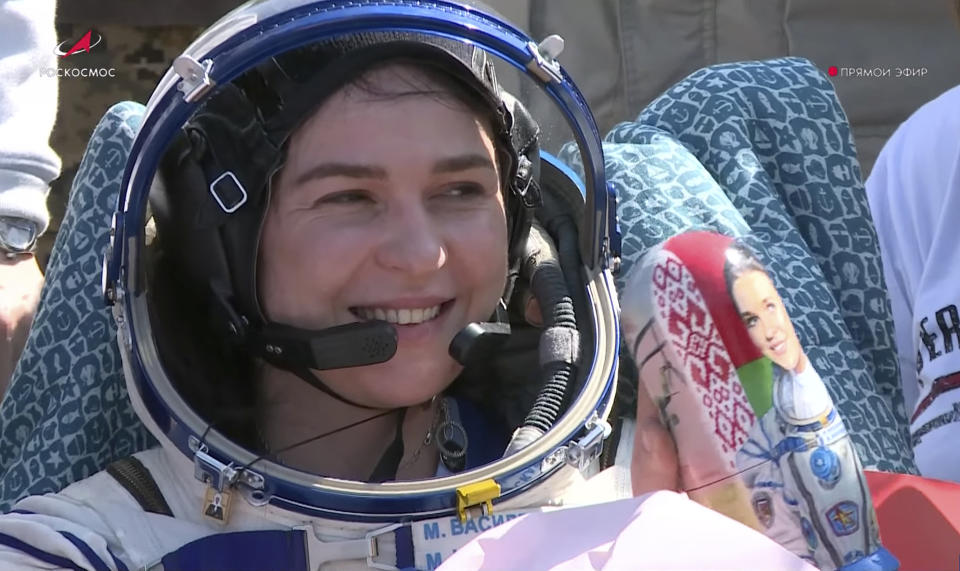 In this grab taken from video released by the Roscosmos Space Corporation Marina Vasilevskaya of Belarus sits in a chair and holds a Matryoshka, Russian traditional wooden dolls depicting her shortly after the landing of the Russian Soyuz MS-24 space capsule, near Zhezkazgan, Kazakhstan, Saturday, April 6, 2024. The Soyuz capsule carrying NASA astronaut Loral O'Hara, Oleg Novitsky of Roscosmos and Marina Vasilevskaya of Belarus touched down on Saturday. (Roscosmos space corporation via AP)