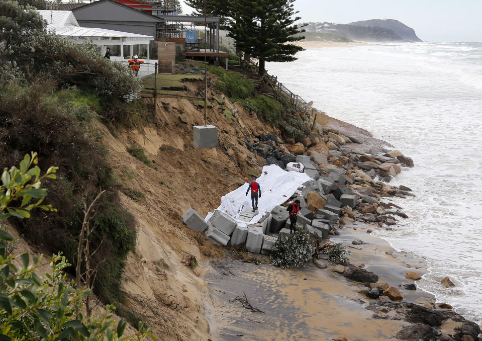 Concrete blocks are craned onto the beach to stop coastal erosion next to houses at Wamberal Beach, on the NSW Central Coast, Saturday, July 18, 2020. 