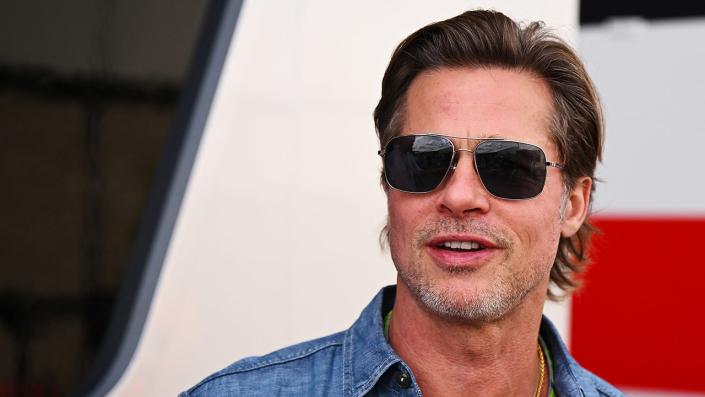 Brad Pitt wearing jeans and dark sunglasses at the Formula 1 race