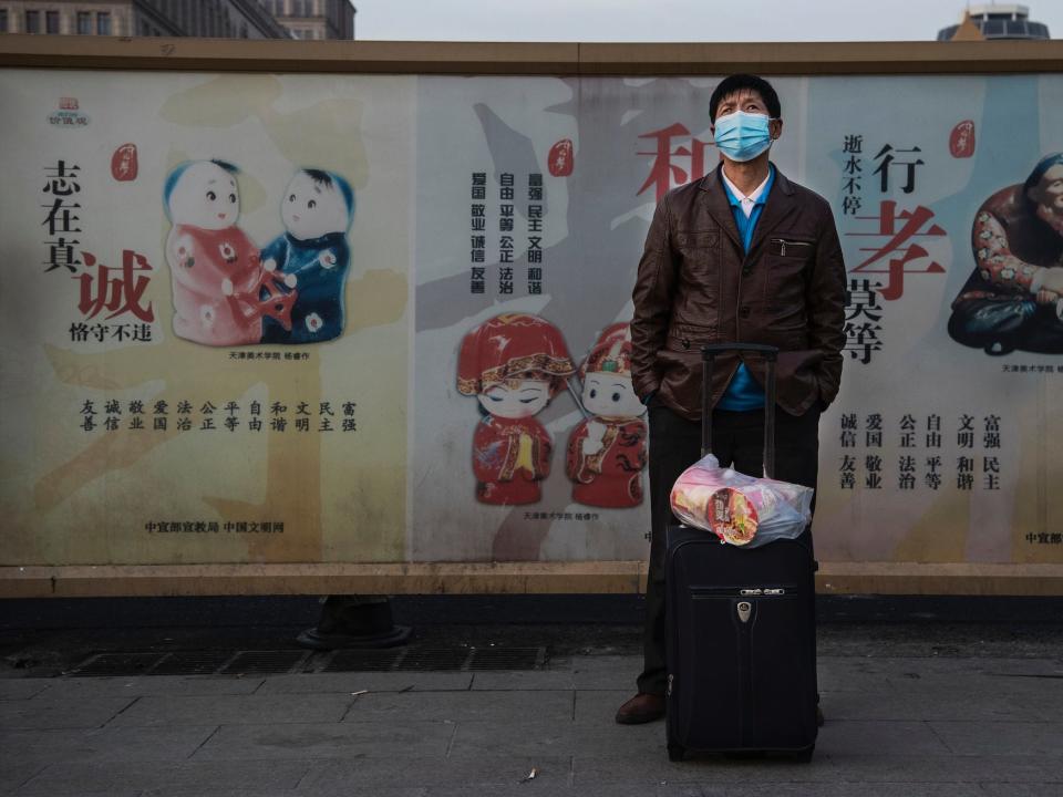 A Chinese man wears a protective mask as he waits to board a train at Beijing Railway station before the annual Spring Festival on January 21, 2020 in Beijing, China.