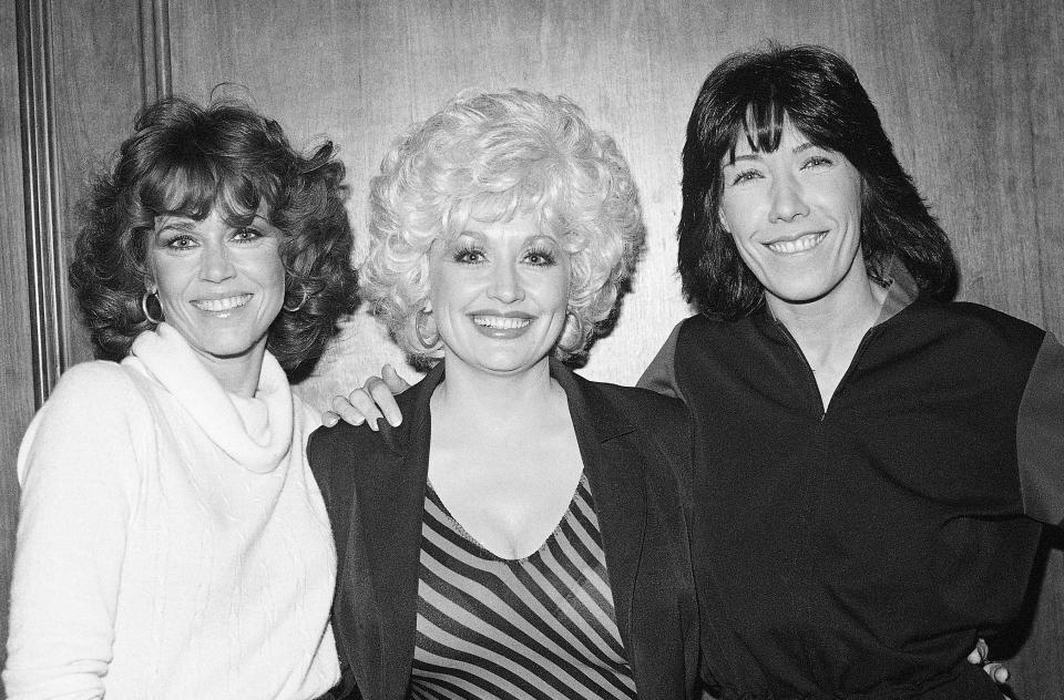 FILE - Jane Fonda, from left, Dolly Parton and Lily Tomlin get together Dec. 12, 1980 at a Los Angeles news conference to promote their movie "9 To 5". Parton's 1980's hit song "9 to 5" has been flipped by Squarespace, the company that helps users build and host their own websites, for a Super Bowl commercial debuting Tuesday, Feb. 2, 2021. Oscar winner Damien Chazelle of "La La Land" fame directed the spot. (AP Photo/Wally Fong, File)