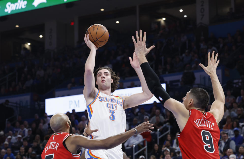 Nov 22, 2023; Oklahoma City, Oklahoma, USA; Oklahoma City Thunder guard Josh Giddey (3) shoots as Chicago Bulls guard Jevon Carter (5) and center Nikola Vucevic (9) defend during the second quarter at Paycom Center. Mandatory Credit: Alonzo Adams-USA TODAY Sports