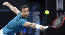 Croatia's Marin Cilic makes a backhand return to Spain's Roberto Bautista Agut during their third round singles match at the Australian Open tennis championship in Melbourne, Australia, Friday, Jan. 24, 2020. (AP Photo/Andy Brownbill)