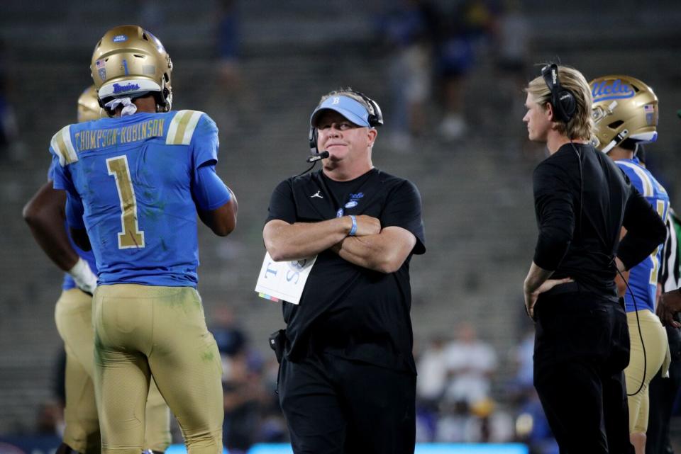 UCLA coach Chip Kelly stands in front of quarterback Dorian Thompson-Robinson.