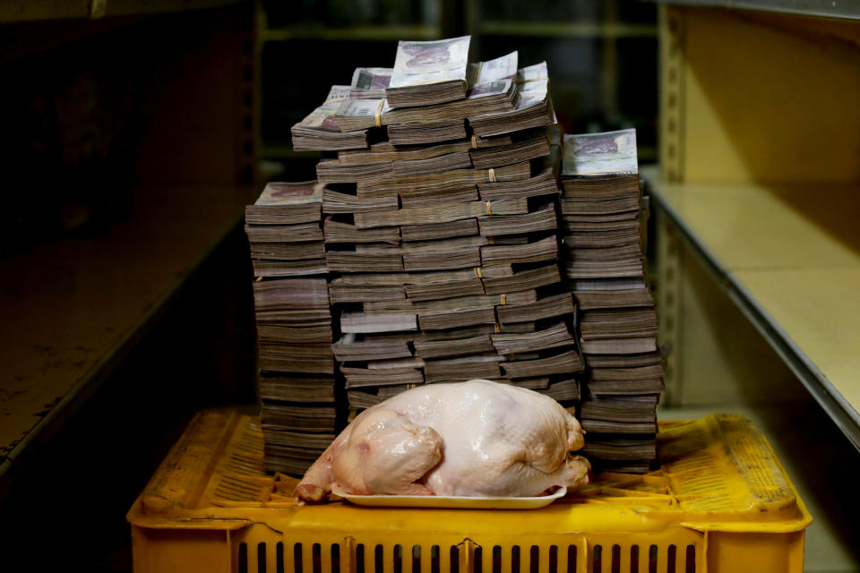 Un pollo de 2,4 kilos es fotografiado junto a la cantidad de 14,6 millones de bolívares, el precio necesario para comprarlo. Equivale a 2,22 dólares. La foto es del 16 de agosto de 2018. (REUTERS/Carlos Garcia Rawlins)