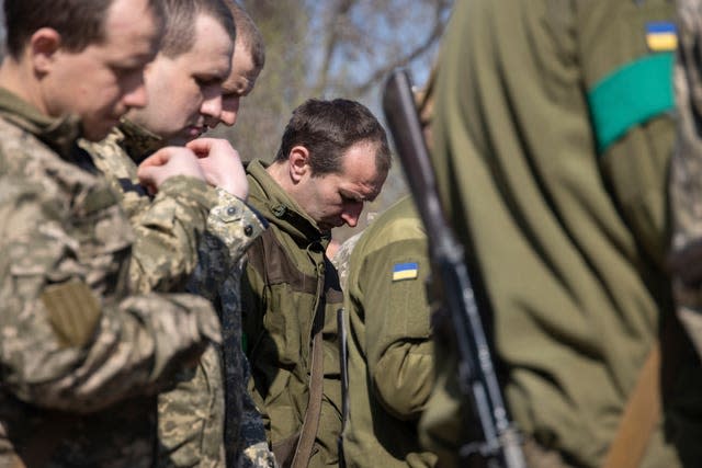 Ukrainian servicemen attend an Orthodox service during the Easter celebration at the frontline position of 128 brigade of Ukrainian army near Zaporizhzhia