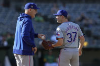 Texas Rangers manager Bruce Bochy, left, hands the ball over to pitcher David Robertson, who replaced Josh Sborz during the sixth inning in the second baseball game of the team's doubleheader against the Oakland Athletics, Wednesday, May 8, 2024, in Oakland, Calif. (AP Photo/Godofredo A. Vásquez)