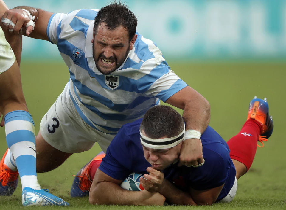 France's Guilhem Guirado, right, is taclked by Argentina's Juan Figallo during the Rugby World Cup Pool C game at Tokyo Stadium between France and Argentina in Tokyo, Japan, Saturday, Sept. 21, 2019. (AP Photo/Christophe Ena)