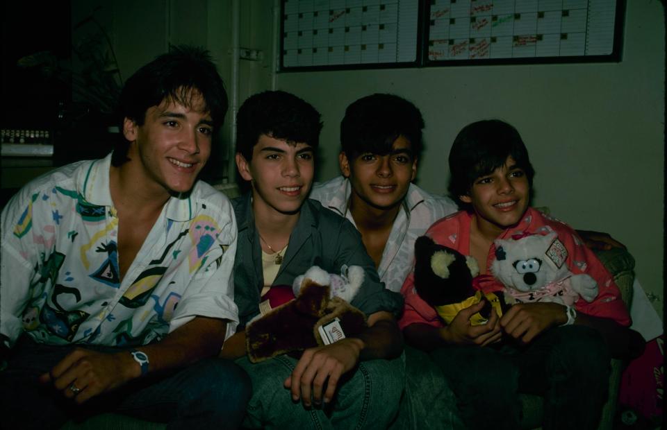 Ricky Martin posing next to Robi 'Draco' Rosa, holding a couple of stuffed animals.