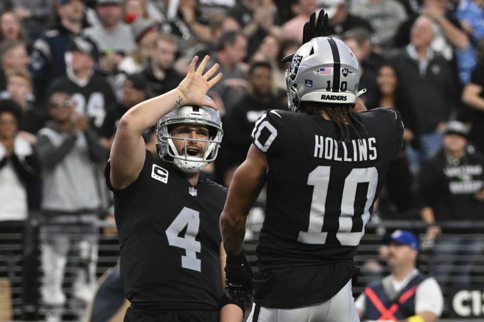 Las Vegas Raiders quarterback Derek Carr congratulates wide receiver Mack Hollins on his touchdown reception during the first half of an NFL football game between the New England Patriots and Las Vegas Raiders, Sunday, Dec. 18, 2022, in Las Vegas. (AP Photo/David Becker)