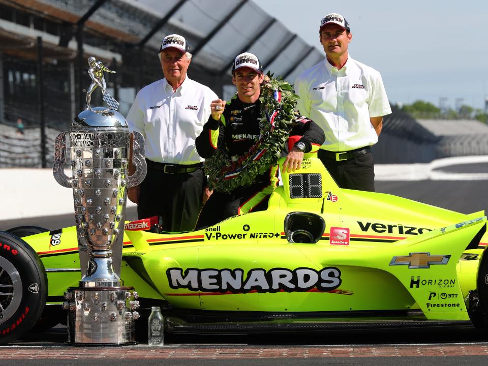 indianapolis 500 racers posing behind their race car