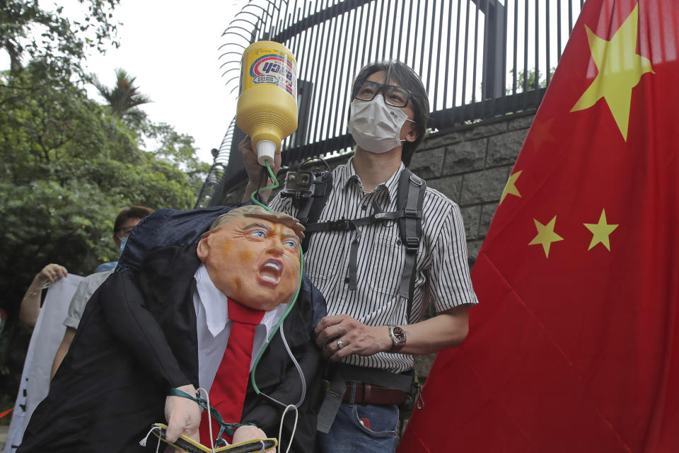 Pro-China supporters hold the effigy of U.S. President Donald Trump and Chinese national flag outside the U.S. Consulate during a protest in Hong Kong, Saturday, May 30, 2020. President Donald Trump has announced a series of measures aimed at China as a rift between the two countries grows. He said Friday that he would withdraw funding from the World Health Organization, end Hong Kong's special trade status and suspend visas of Chinese graduate students suspected of conducting research on behalf of their government. (AP Photo/Kin Cheung)