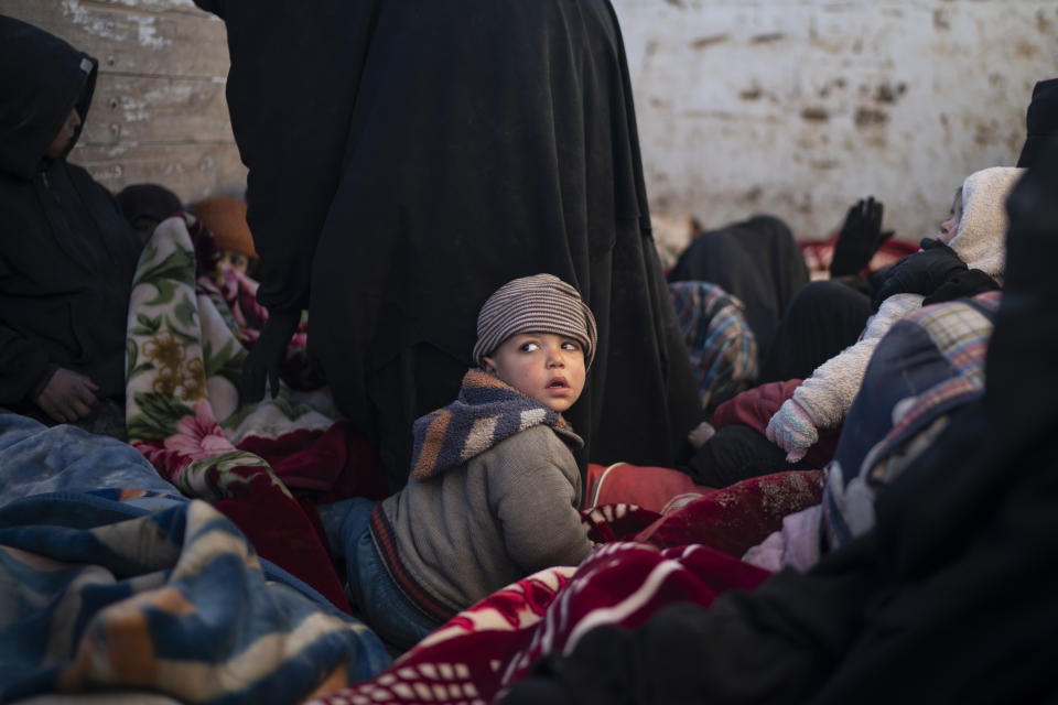 Women and children sit in the back of a truck as they wait to be screened by U.S.-backed Syrian Democratic Forces (SDF) after being evacuated out of the last territory held by Islamic State militants, in the desert outside Baghouz, Syria, Friday, March 1, 2019. (AP Photo/Felipe Dana)