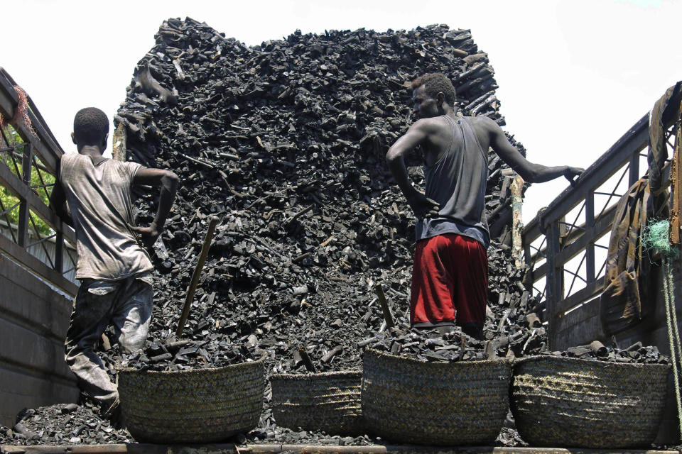 In this photo of Tuesday Oct. 30, 2012, Somali porters offload charcoal from a truck at a charcoal market in Mogadishu, Somali . Thousands of sacks of dark charcoal sit atop one another in Somalia's southern port city of Kismayo, an industry once worth some $25 million dollar a year to the al-Qaida-linked insurgents who controlled the region. The good news sitting in the idle pile of sacks is that al-Shabab militants can no longer fund their insurgency through the illegal export of the charcoal. Kenyan troops late last month invaded Kismayo and forced out the insurgents, putting a halt to the export of charcoal, a trade the U.N. banned earlier this year in an effort to cut militant profits. The loss of the charcoal trade "will cut a major source of revenue and thus will have a detrimental effect on their operational capacity to carry out large scale attacks," Mohamed Sheikh Abdi, a Somali political analyst, said of al-Shabab. But the flip side to the charcoal problem is that residents who made their living from the trade no longer are making money, a potentially tricky issue for the Kenyan troops who now control the region. (AP Photo/Farah Abdi Warsameh)