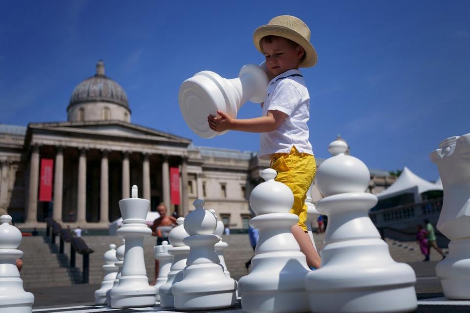 A young boy wearing his sun hat takes part in ChessFest, the UK’s largest one-day chess event, at Trafalgar Square in central London (Victoria Jones/PA) (PA Wire)