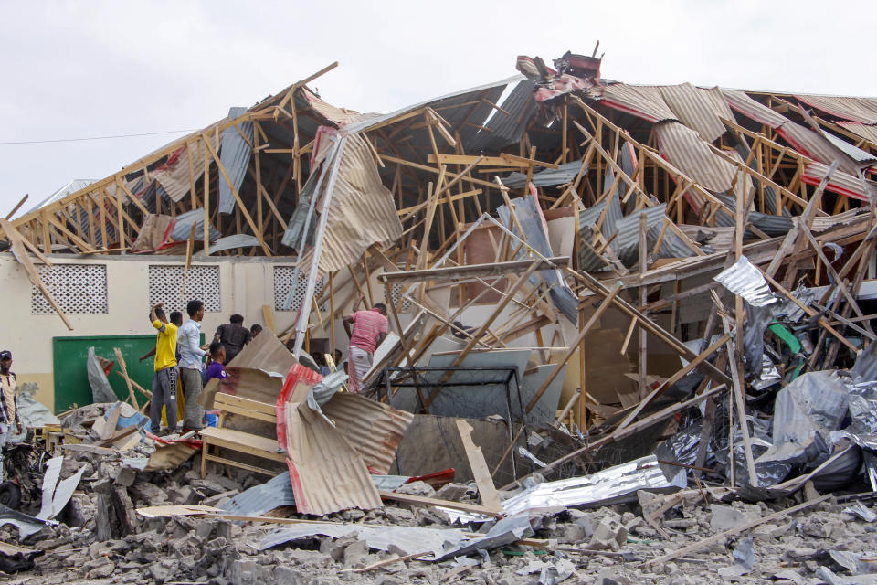 People search for bodies at the scene of a blast in Mogadishu, Somalia Thursday, Nov. 25, 2021. Witnesses say a large explosion has occurred in a busy part of Somalia's capital during the morning rush hour. (AP Photo/Farah Abdi Warsameh)