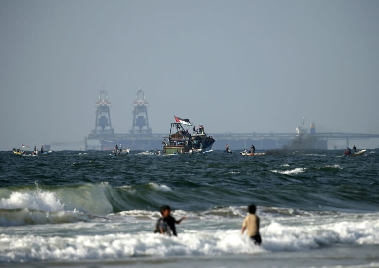 Palestinian boats participate in a protest against the more than a decade-long blockade of Gaza on August 11, 2018 with Israel's Rutenberg power station seen in the background