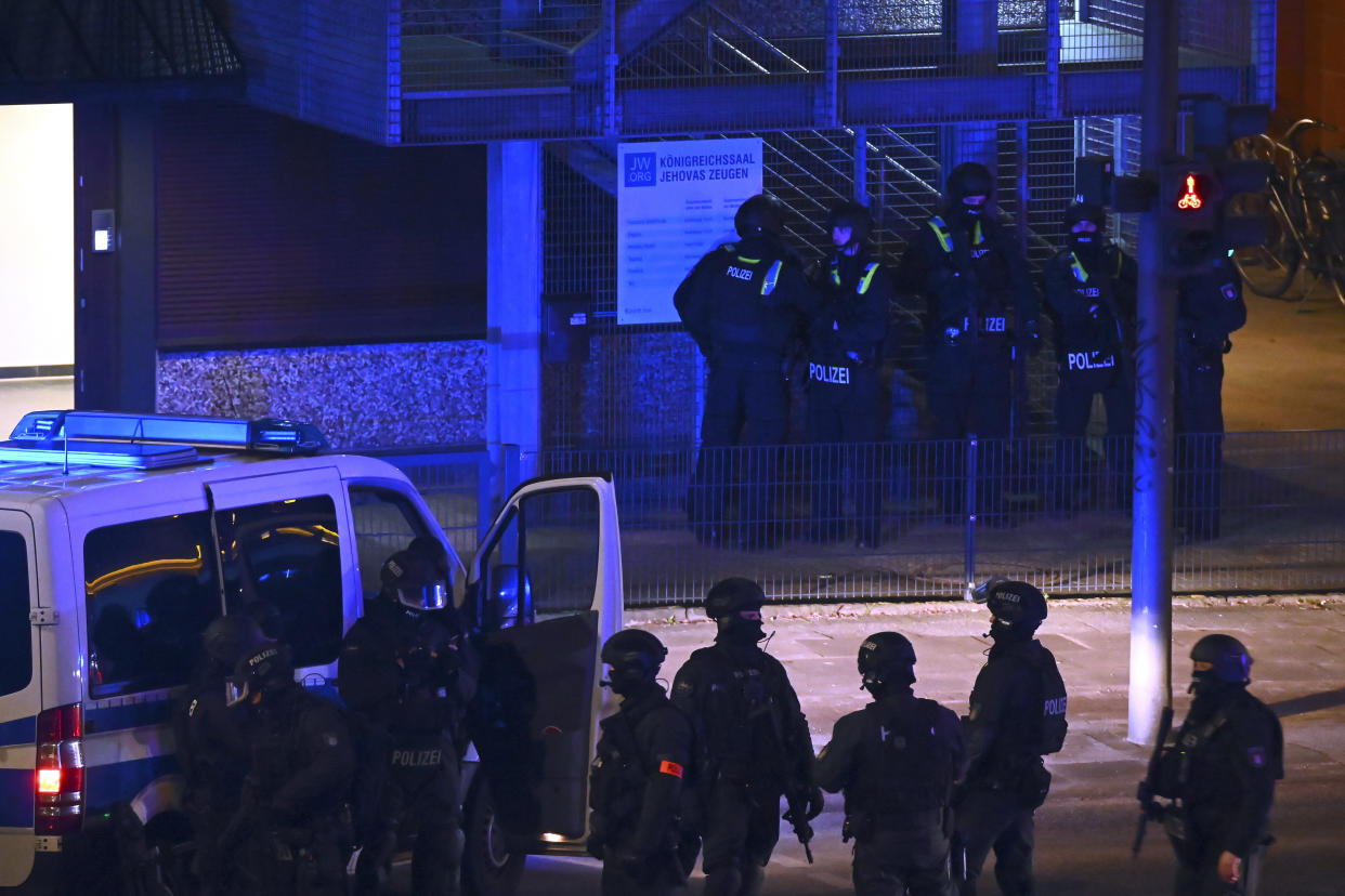 Armed police officers near the scene of a shooting in Hamburg, Germany on Thursday March 9, 2023 after one or more people opened fire in a church. The Hamburg city government says the shooting took place in the Gross Borstel district on Thursday evening. (Jonas Walzberg/dpa via AP)