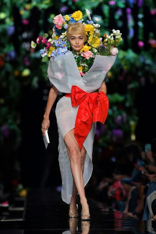 Model Gigi Hadid presents a creation for fashion house Moschino under the creative lead of American Jeremy Scott