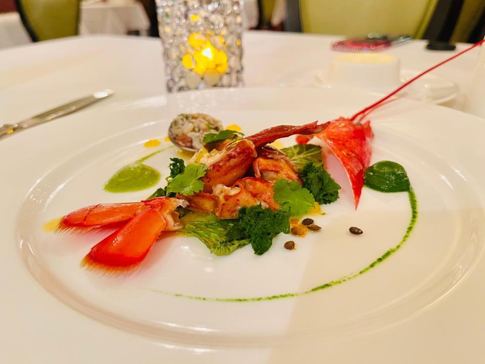 Plate of lobster with green sauce.