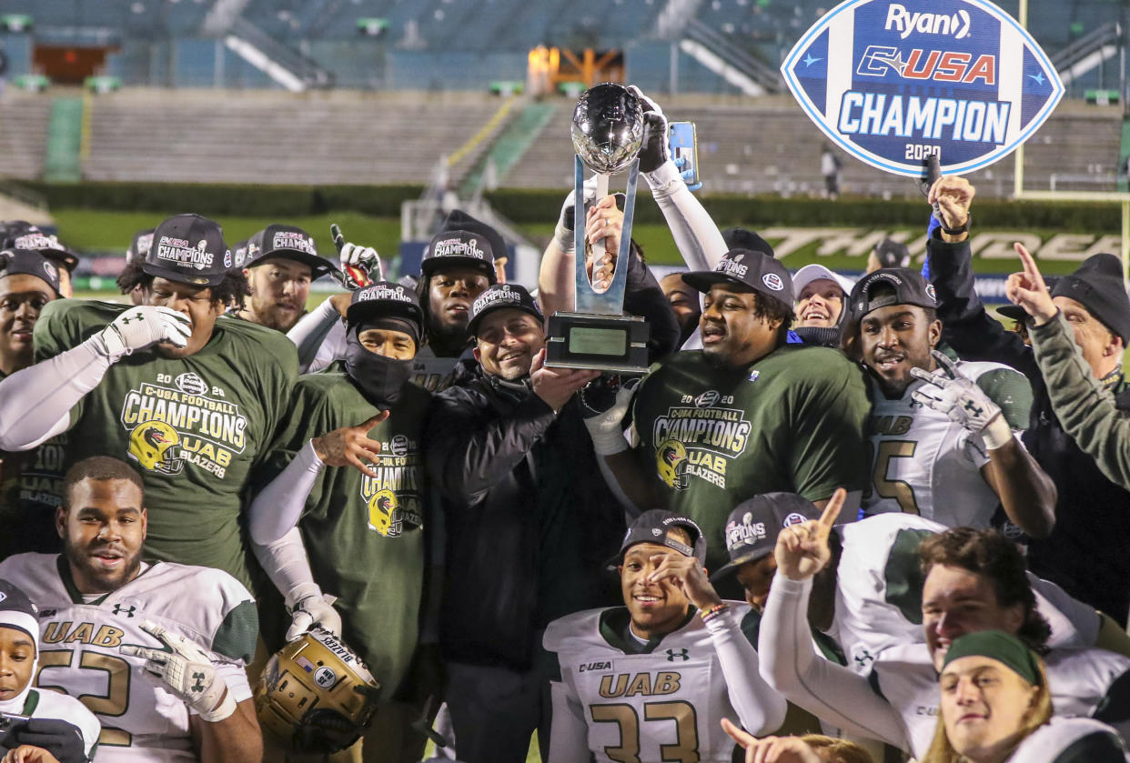 Dec 18, 2020; Huntington, West Virginia, USA; UAB Blazers head coach Bill Clark raises the trophy and celebrates with his players after defeating the Marshall Thundering Herd for the Conference USA Championship at Joan C. Edwards Stadium. Mandatory Credit: Ben Queen-USA TODAY Sports