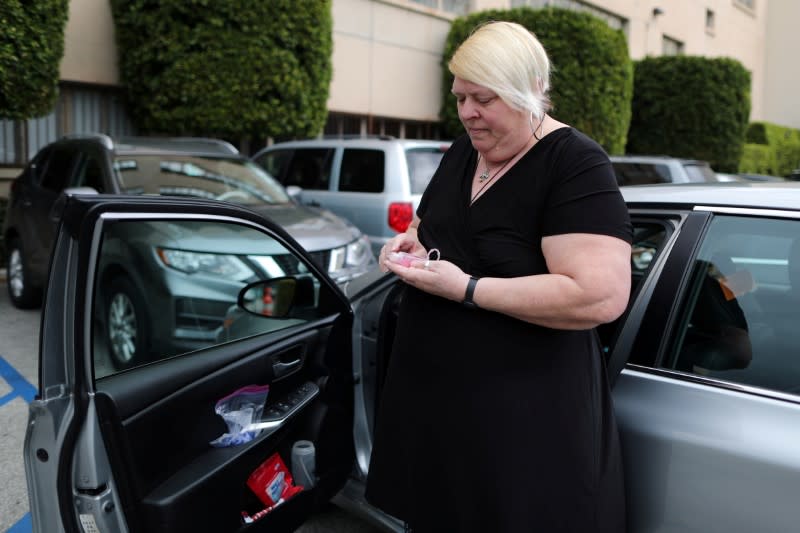 FILE PHOTO: Uber and Lyft driver Tammie Jean Lane, 60, who had part of her lung removed after lung cancer, holds a bottle of hand sanitizer during the global outbreak of coronavirus (COVID-19) in Los Angeles