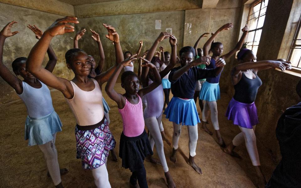 In this photo taken Friday, Dec. 9, 2016, young ballerinas receive instruction from Kenyan ballet dancer Joel Kioko, 16, in a room at a school in the Kibera slum of Nairobi, Kenya. In a country not usually associated with classical ballet, Kenya's most promising young ballet dancer Joel Kioko has come home for Christmas from his training in the United States, to dance a solo in The Nutcracker and teach holiday classes to aspiring dancers in Kibera, the Kenyan capital's largest slum. (AP Photo/Ben Curtis)